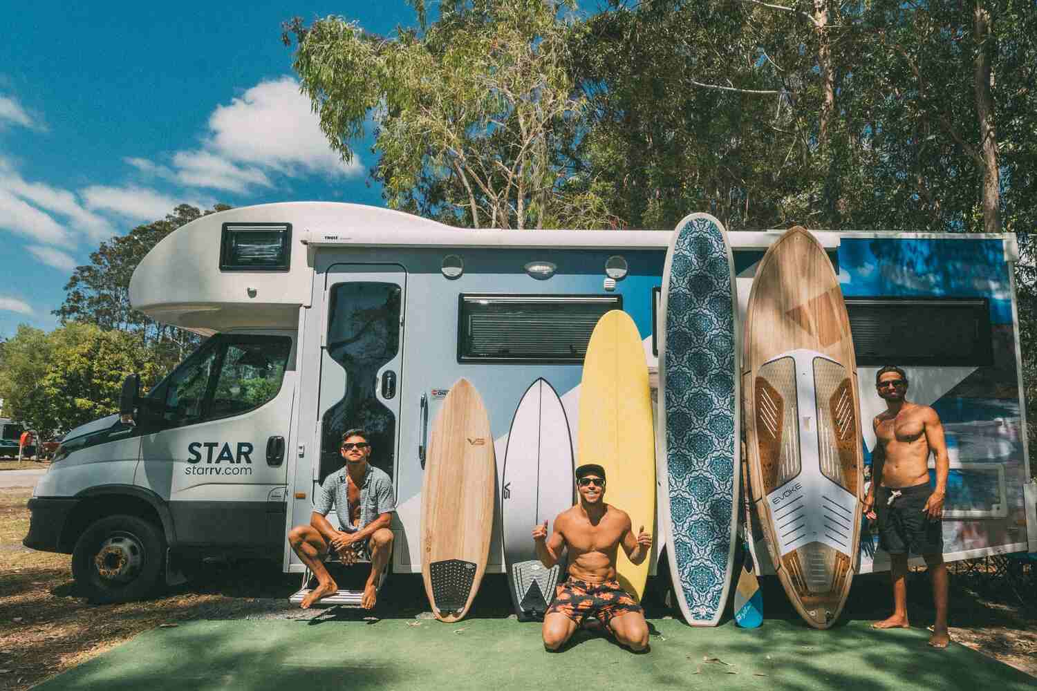 Surfers posing by Star RV motorhome