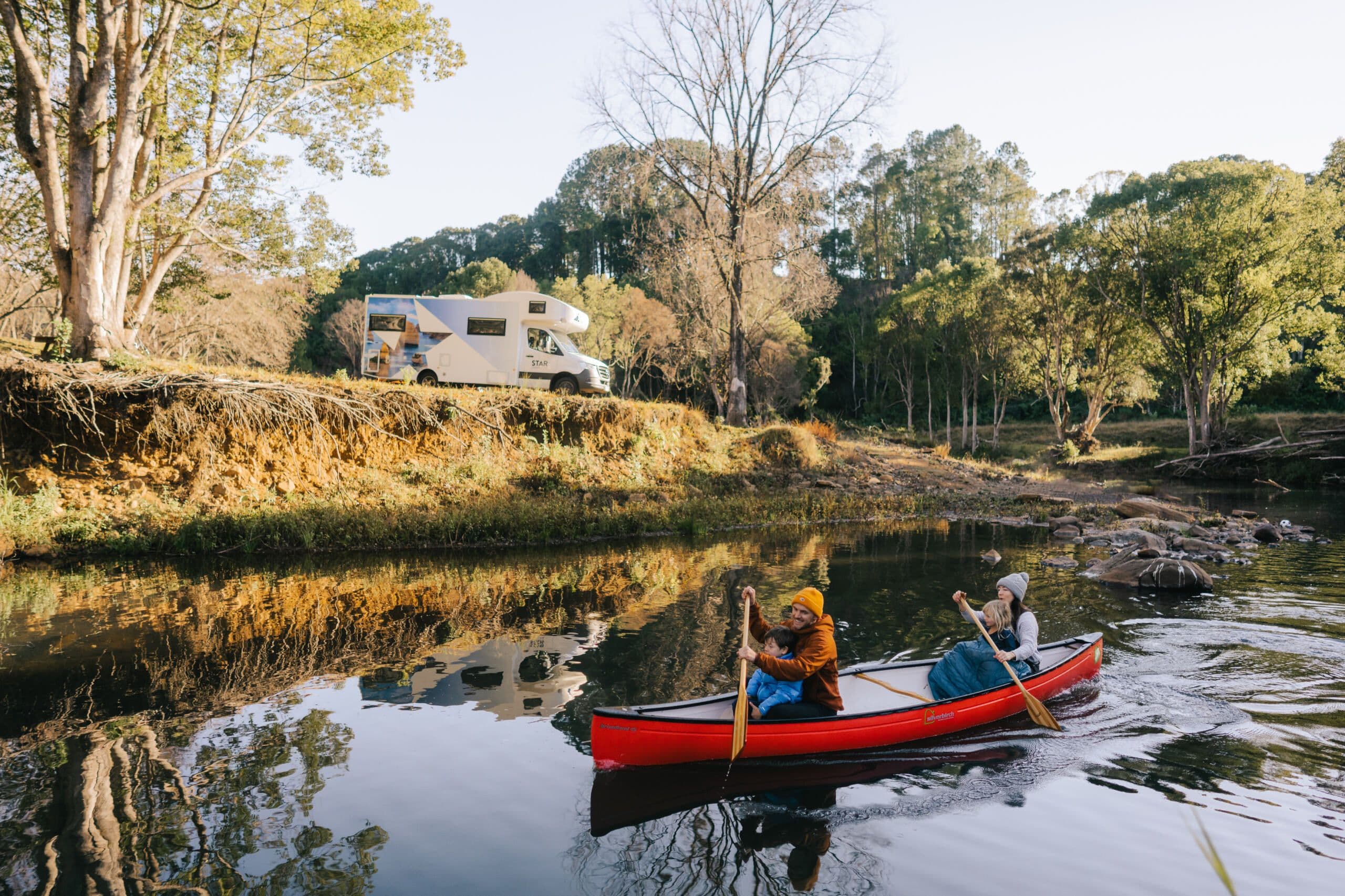Family of 4 enjoying a kayak trip down a river